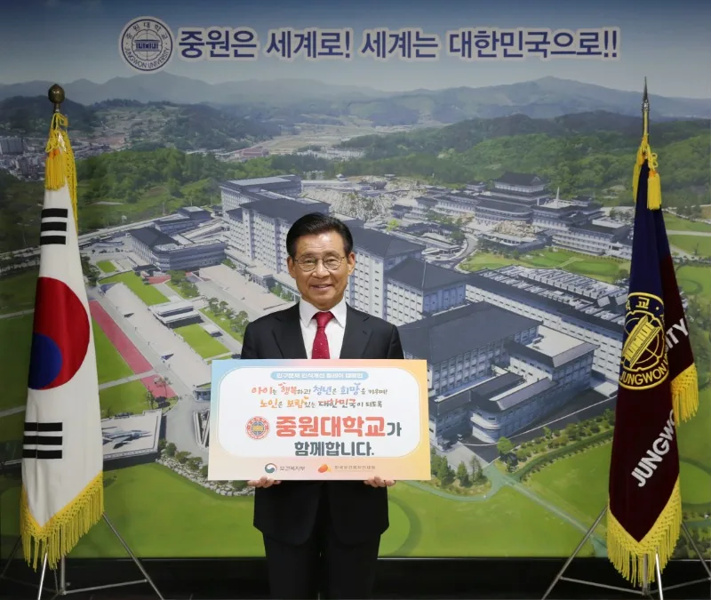 황윤원 총장이 「중원대학교가 함께합니다」라고 적힌 인구문제 인식 개선 캠페인 팻말을 들고 있는 모습