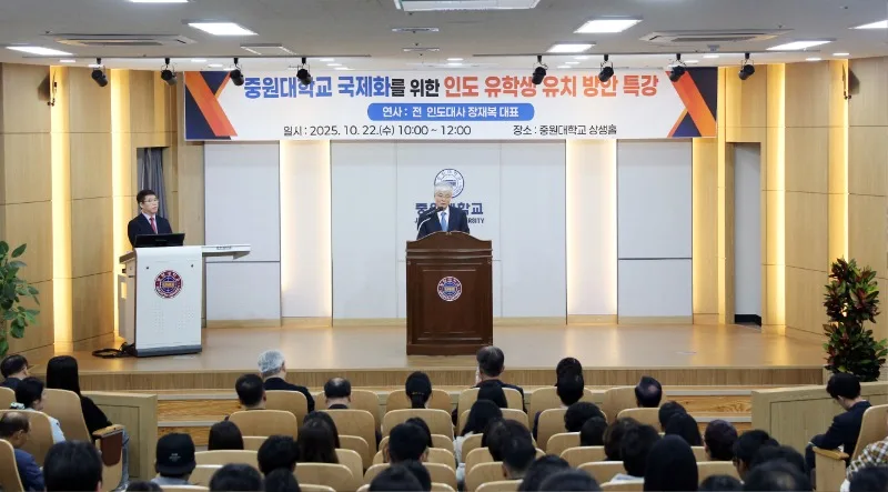특강 현수막이 걸린 무대 연단에서 인사말을 하는 모습