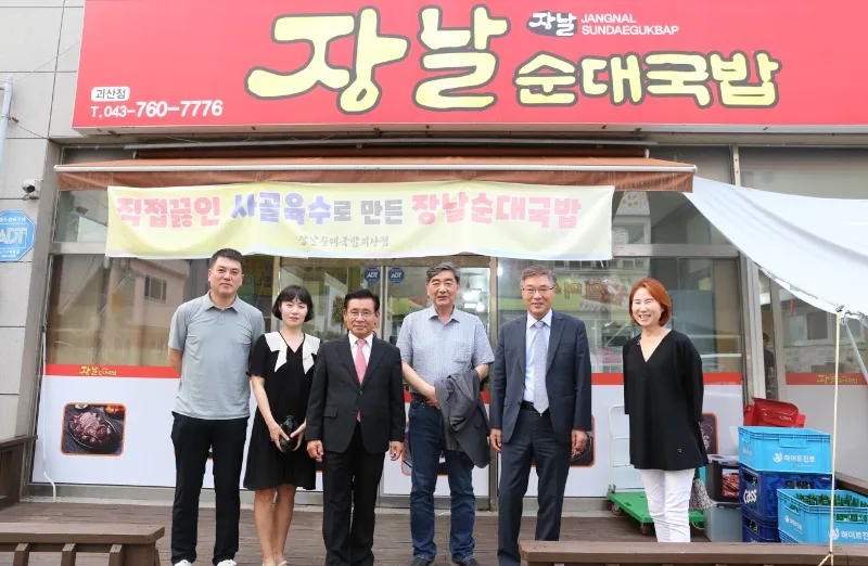 황윤원 총장과 교수들이 후원의 집인 「장날순대국밥」 앞에서 기념 촬영한 모습